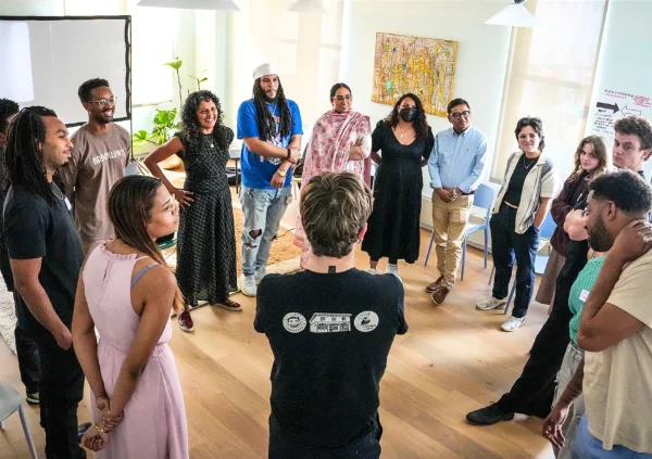 Diverse group of people standing in a circle during a community gathering.