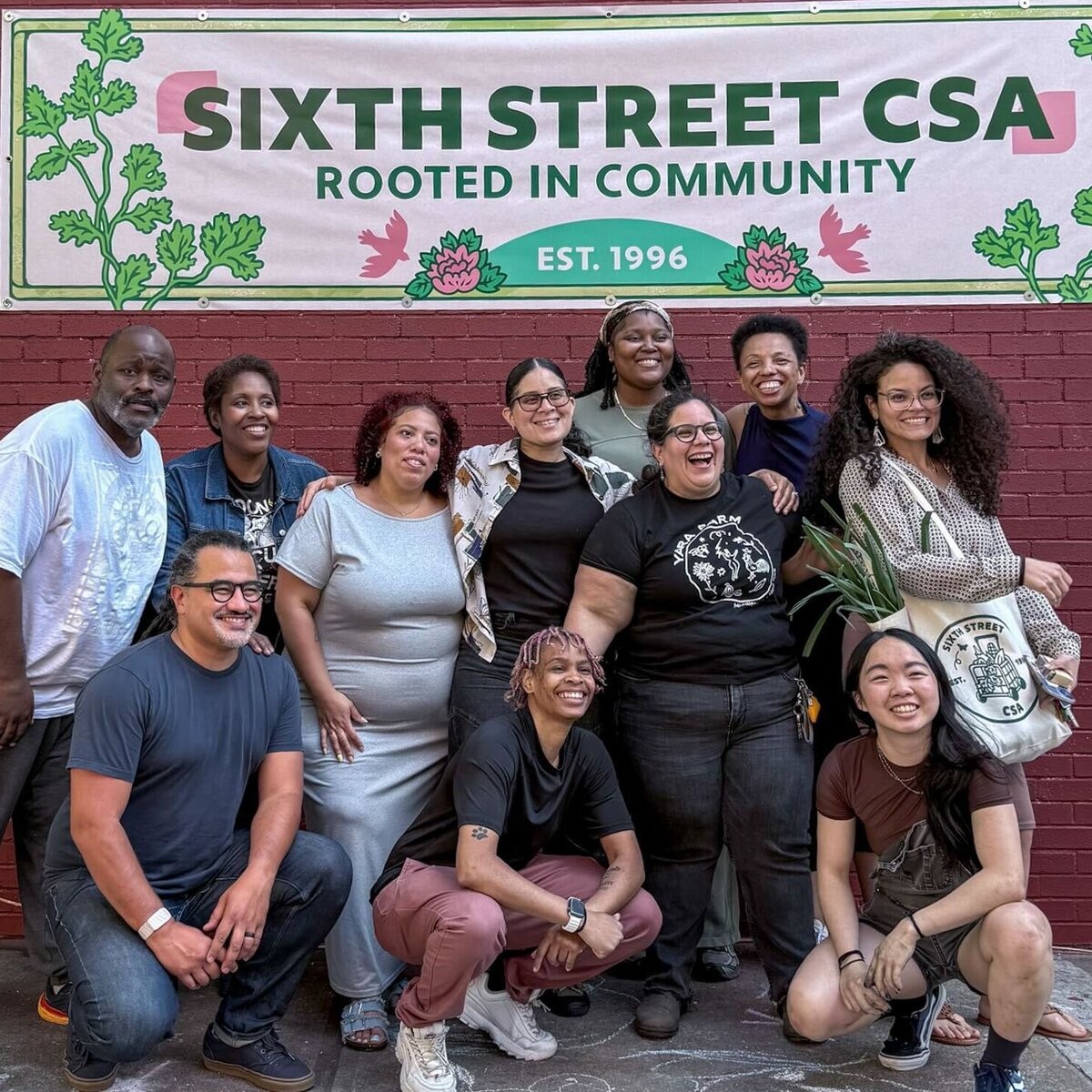 Sixth Street Community Center members gathered beneath their CSA sign.