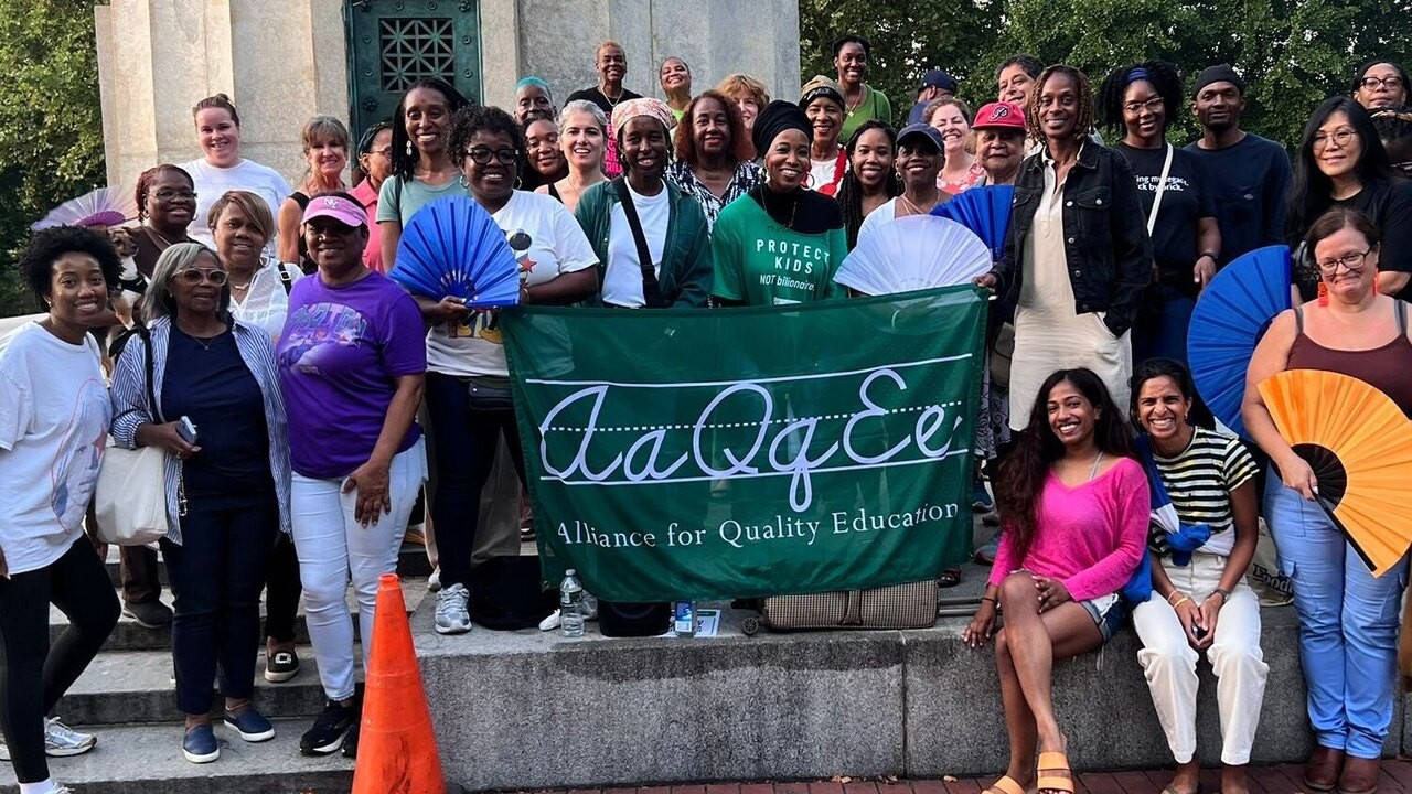 Alliance for Quality Education members and supporters holding an AQE banner.