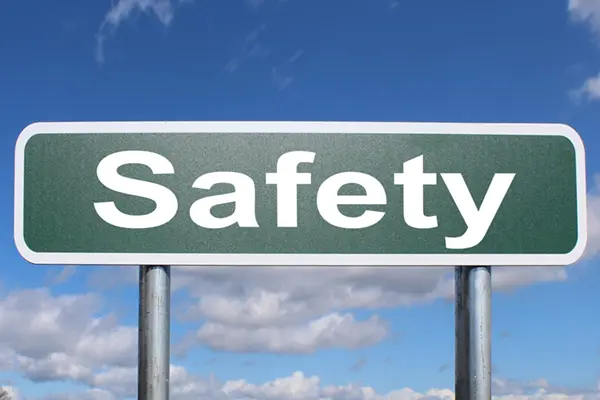 Green road sign reading Safety against a blue sky