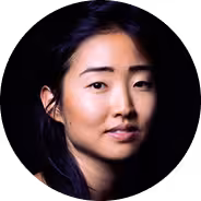 Portrait of a woman with dark hair against a black background.