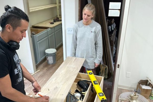 two persons repairing house room