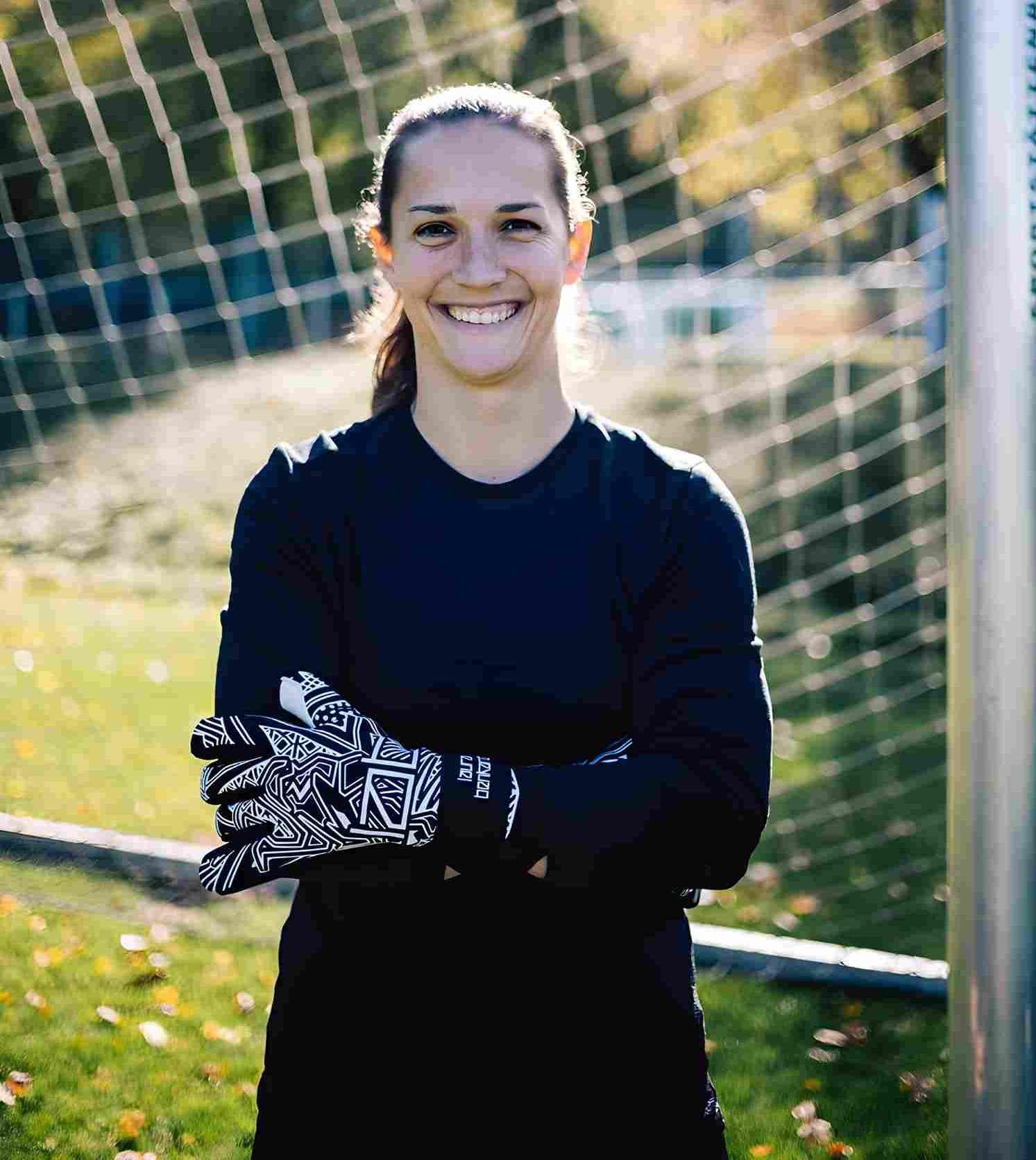 Fußballtorfrau Laura Benkarth trägt die Meisterschale und feiert mit ihrer Mannschaft auf dem Spielfeld.