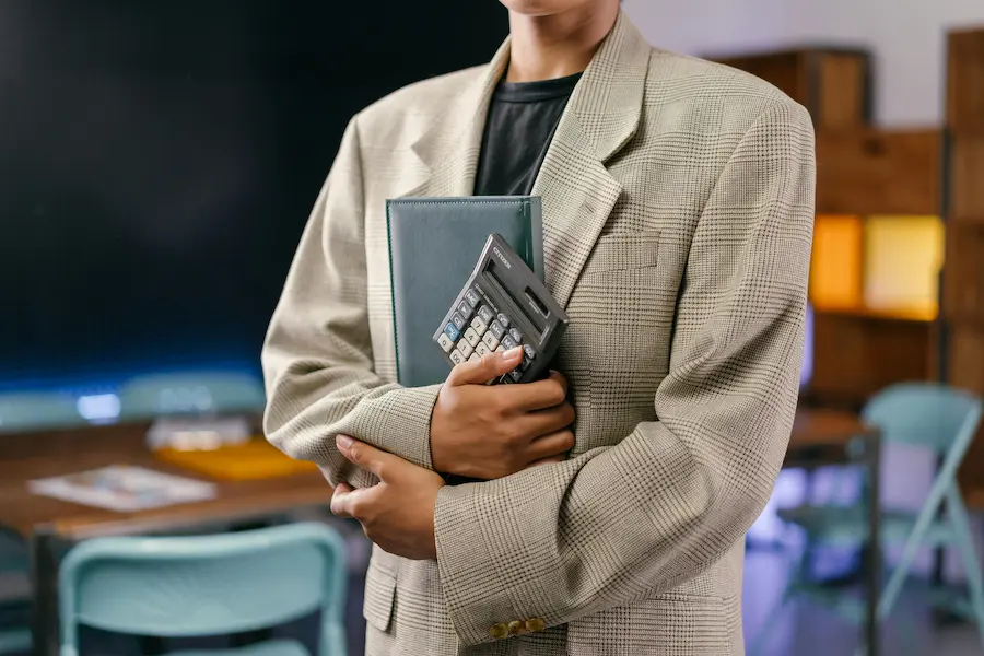 Une freelance en recrutement bras croisés avec calculatrice