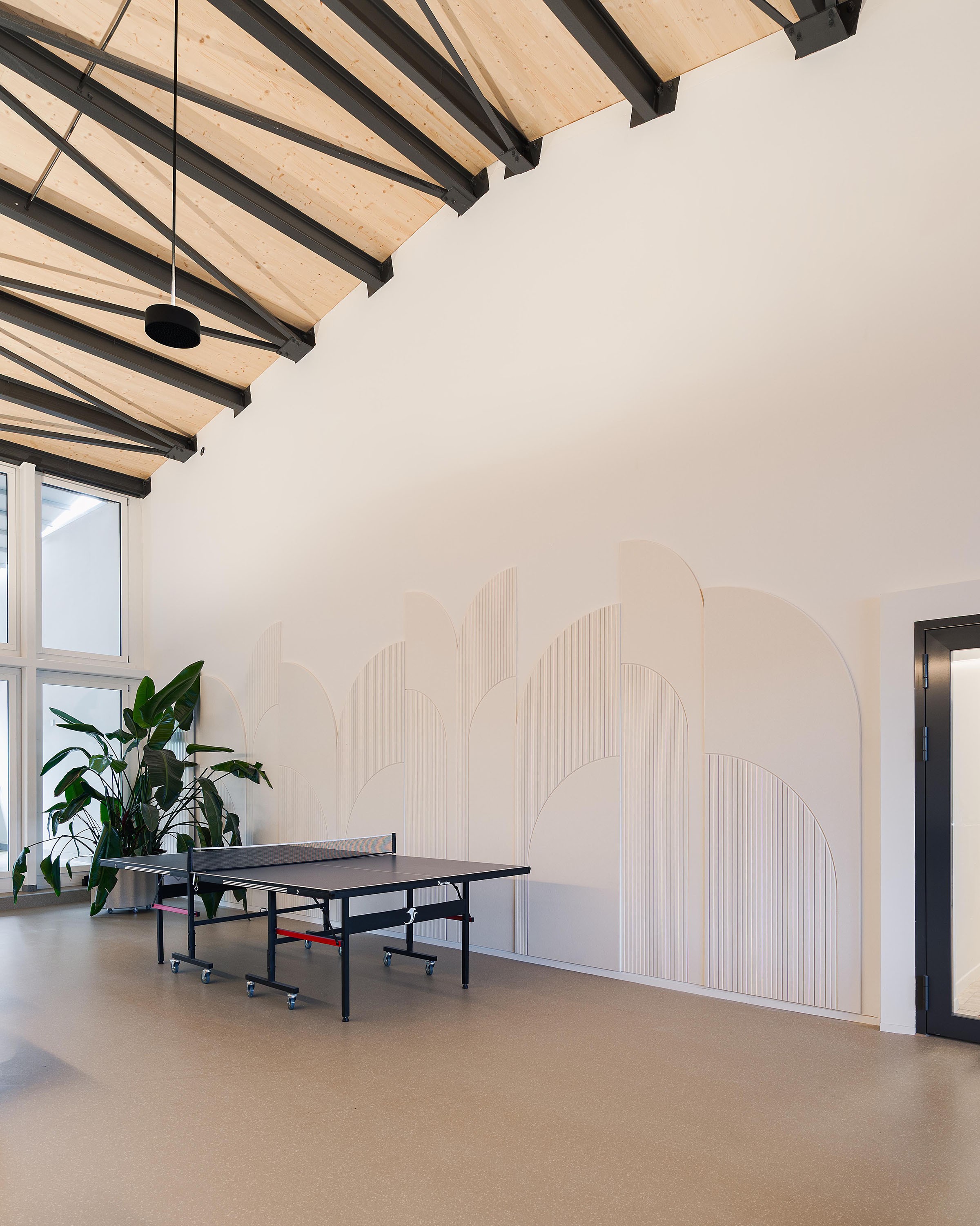 Akustikelemente an der Wand im Aufenthaltsbereich von Cosa Mirai mit Pingpong-Tisch