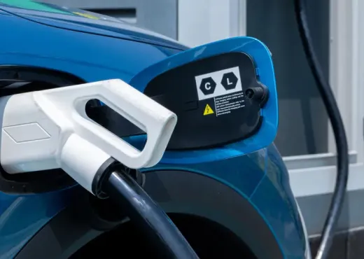 Close-up of an electric car charging with a cable plugged into the port.