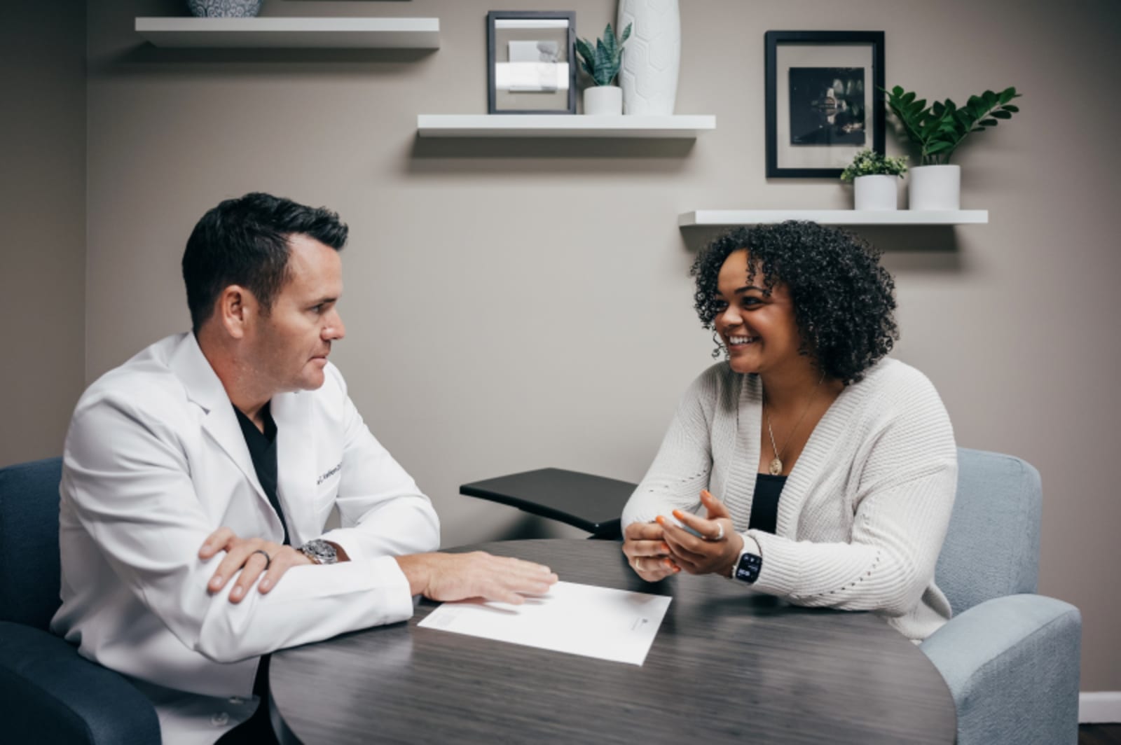 Male dentist consulting with female patient in dental office setting