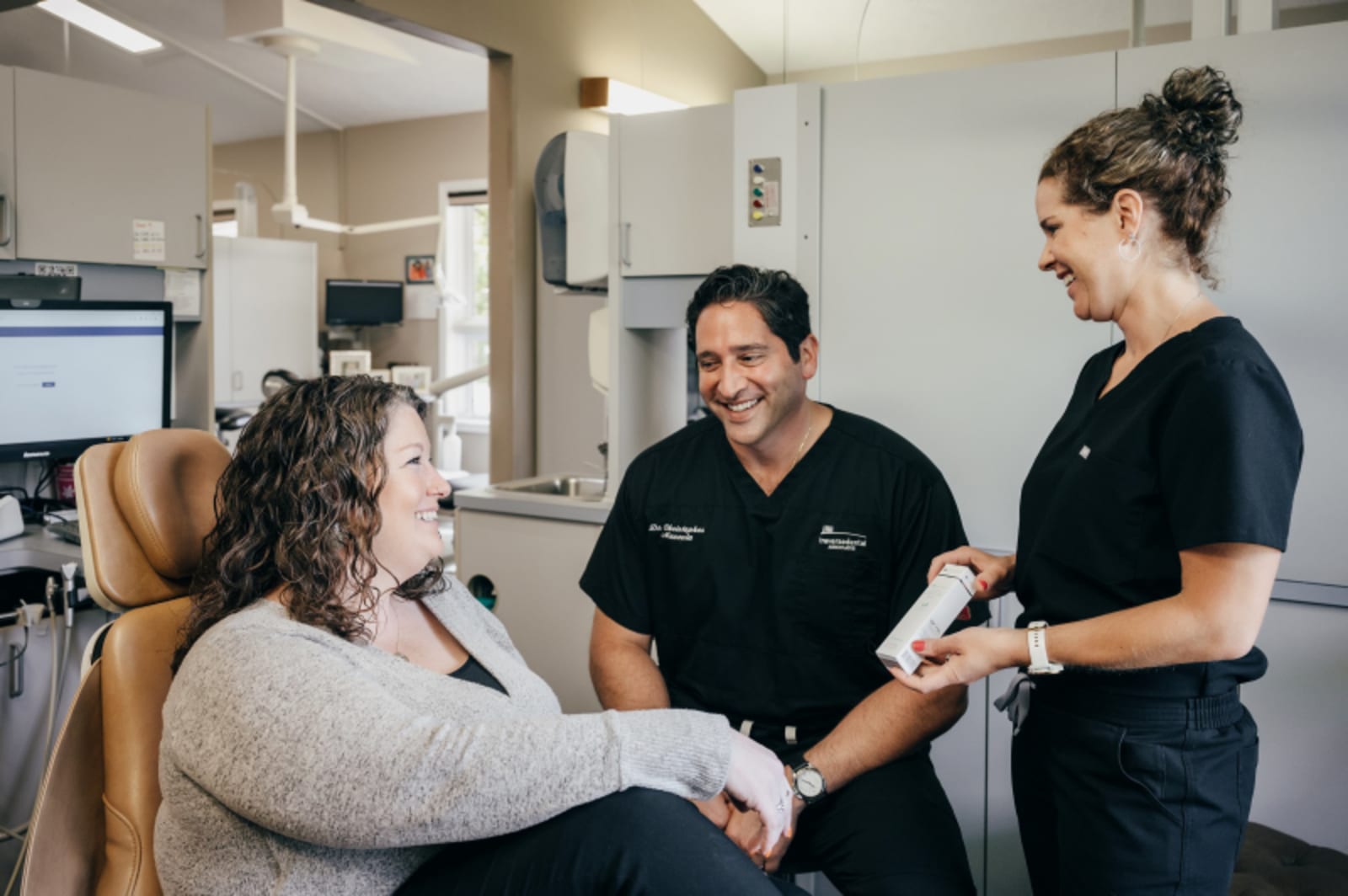 Dentist examining patient in clinical treatment room during dental procedure