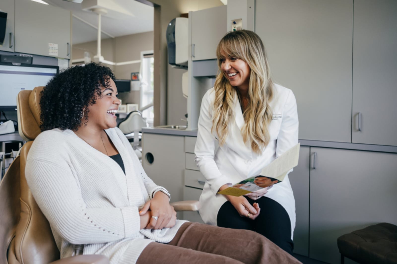 Female dentist discussing treatment plan with patient in consultation room
