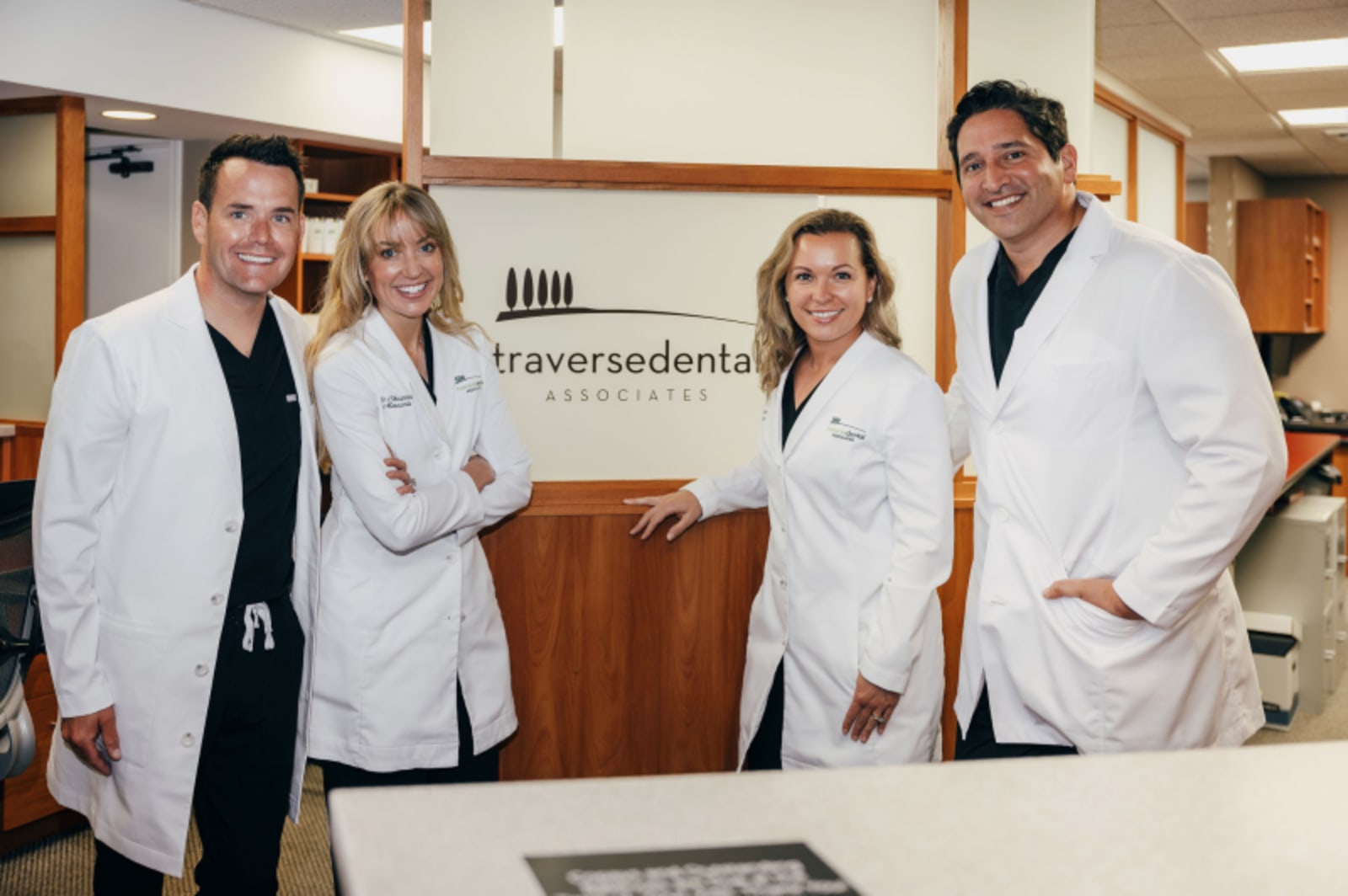 Traverse Dental Associates team in white coats standing together in office