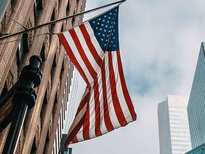 Amerikanische Flagge weht vor Backsteingebäude und modernen Wolkenkratzern