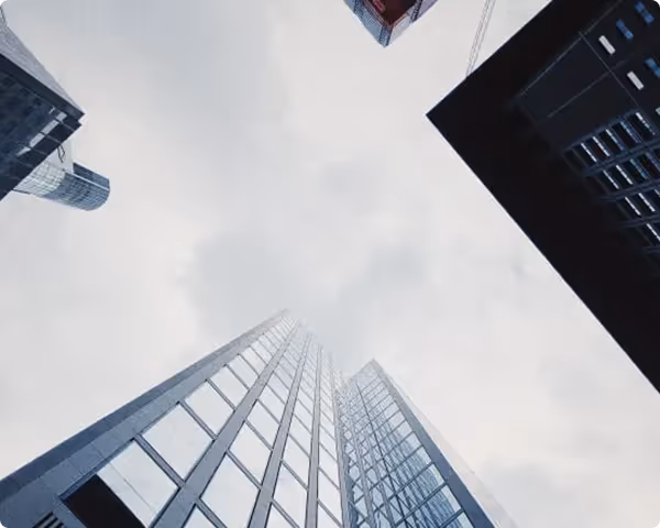Wolkenkratzer von unten, moderne Glasfassaden in grau-blauer Perspektive