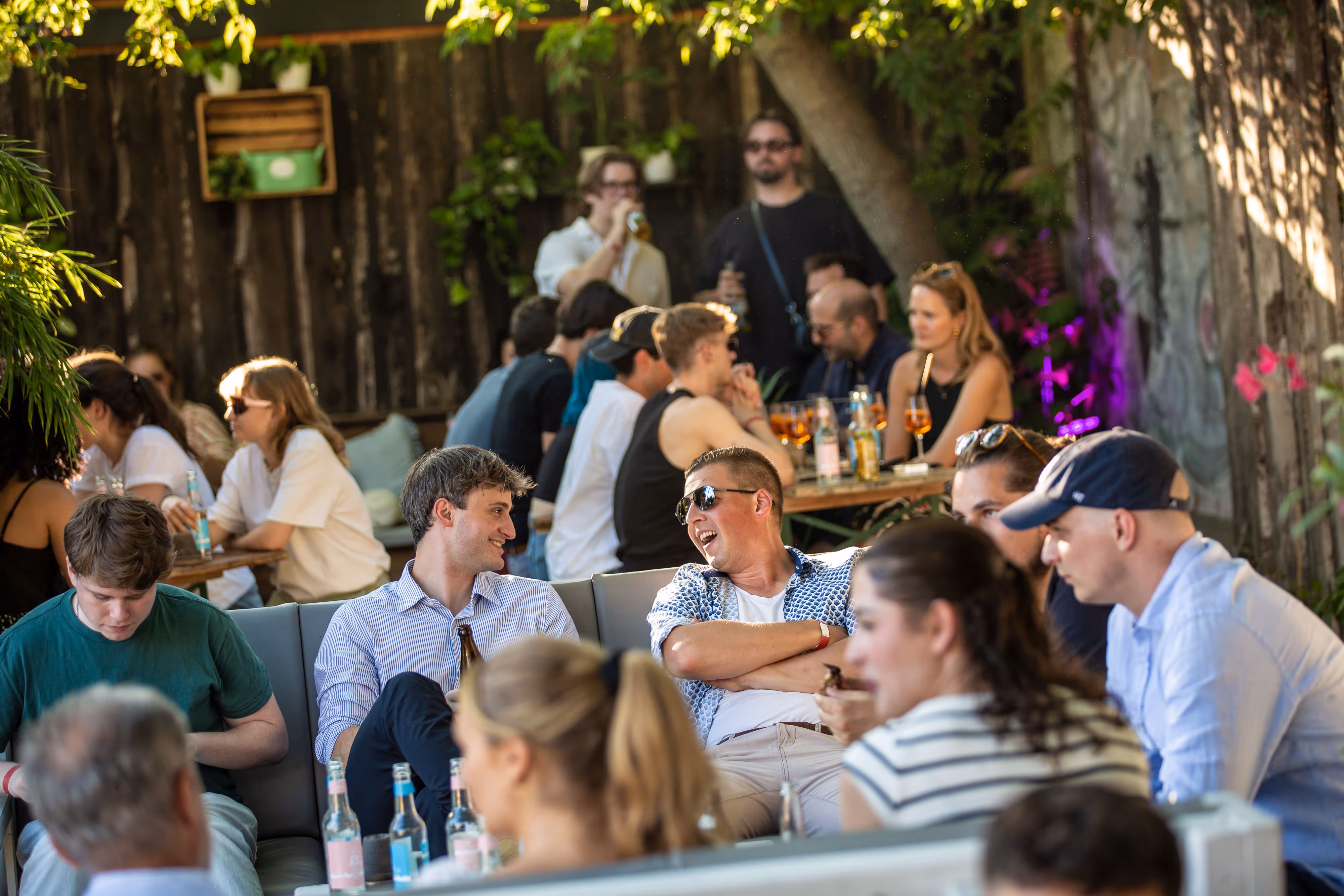 Belebte Bar im Freien mit Menschen, die Getränke trinken und sich unterhalten