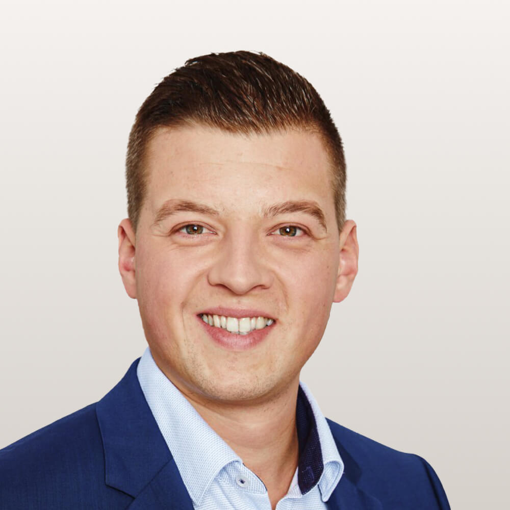 Senior Client Investment Manager im Anzug vor weißem Hintergrund