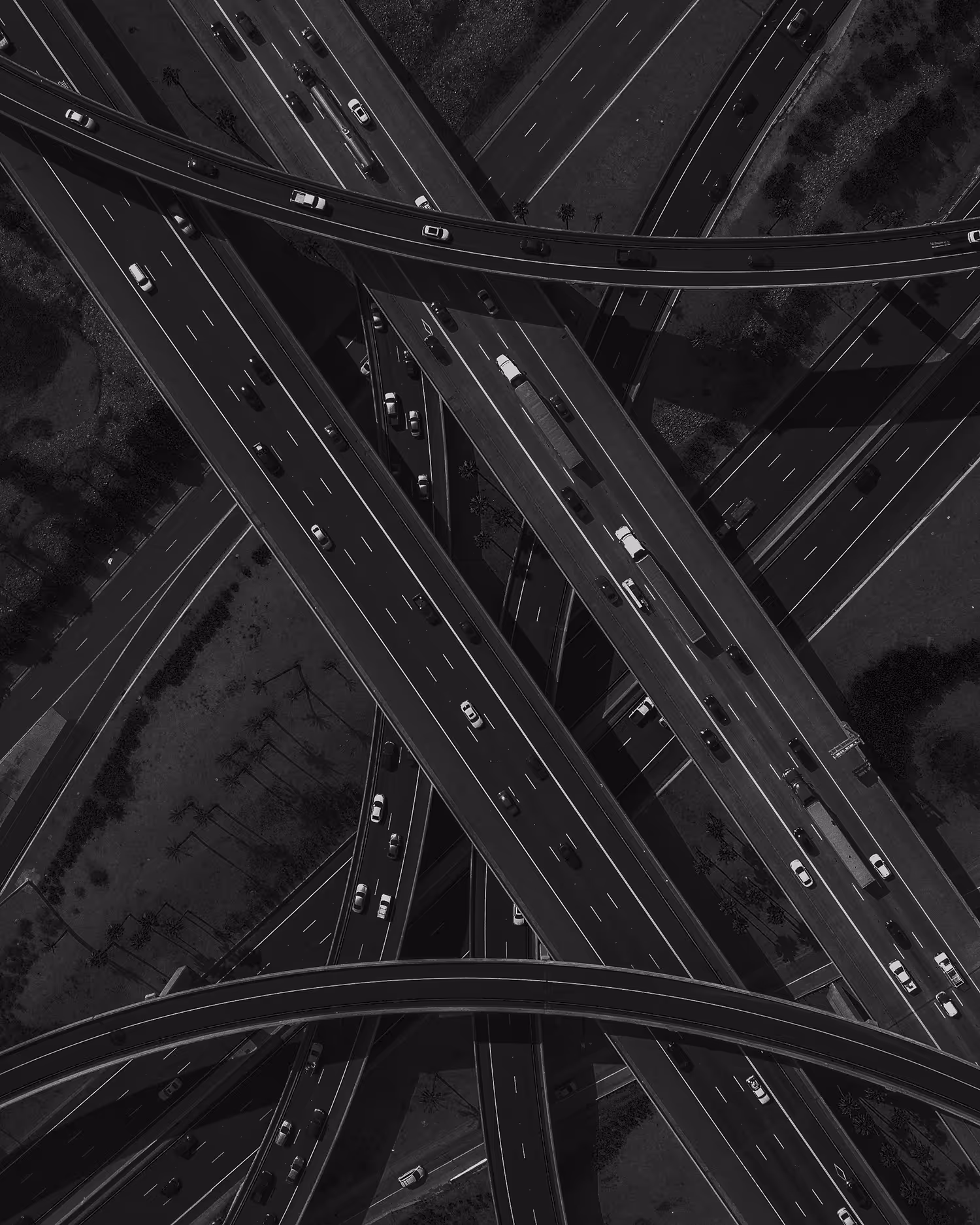 Luftaufnahme eines komplexen Autobahnkreuzes mit verschlungenen Straßen und Autos