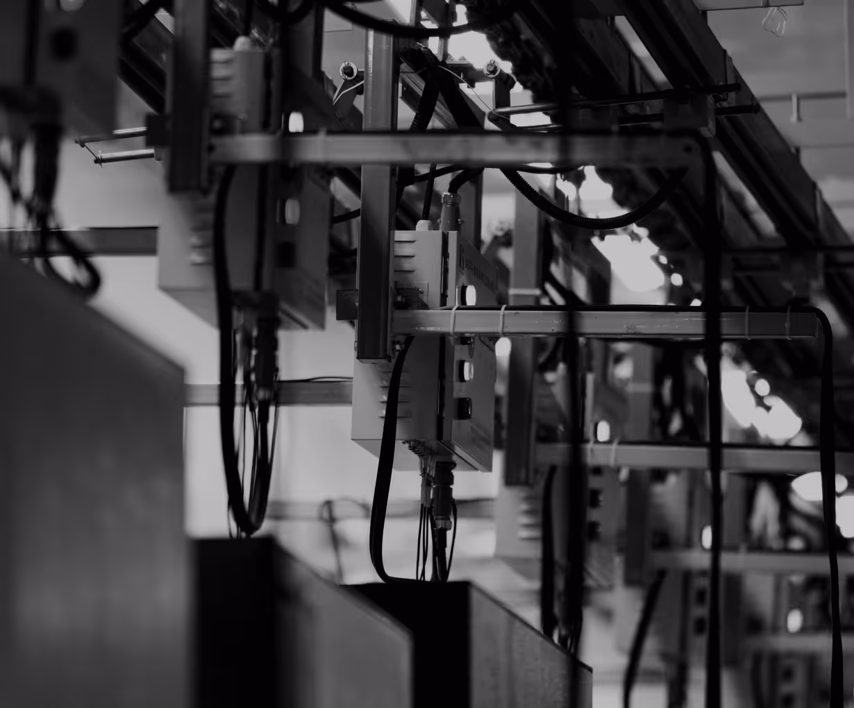 Schwarzweiße industrielle Maschinerie mit Kabeln und Metallstreben