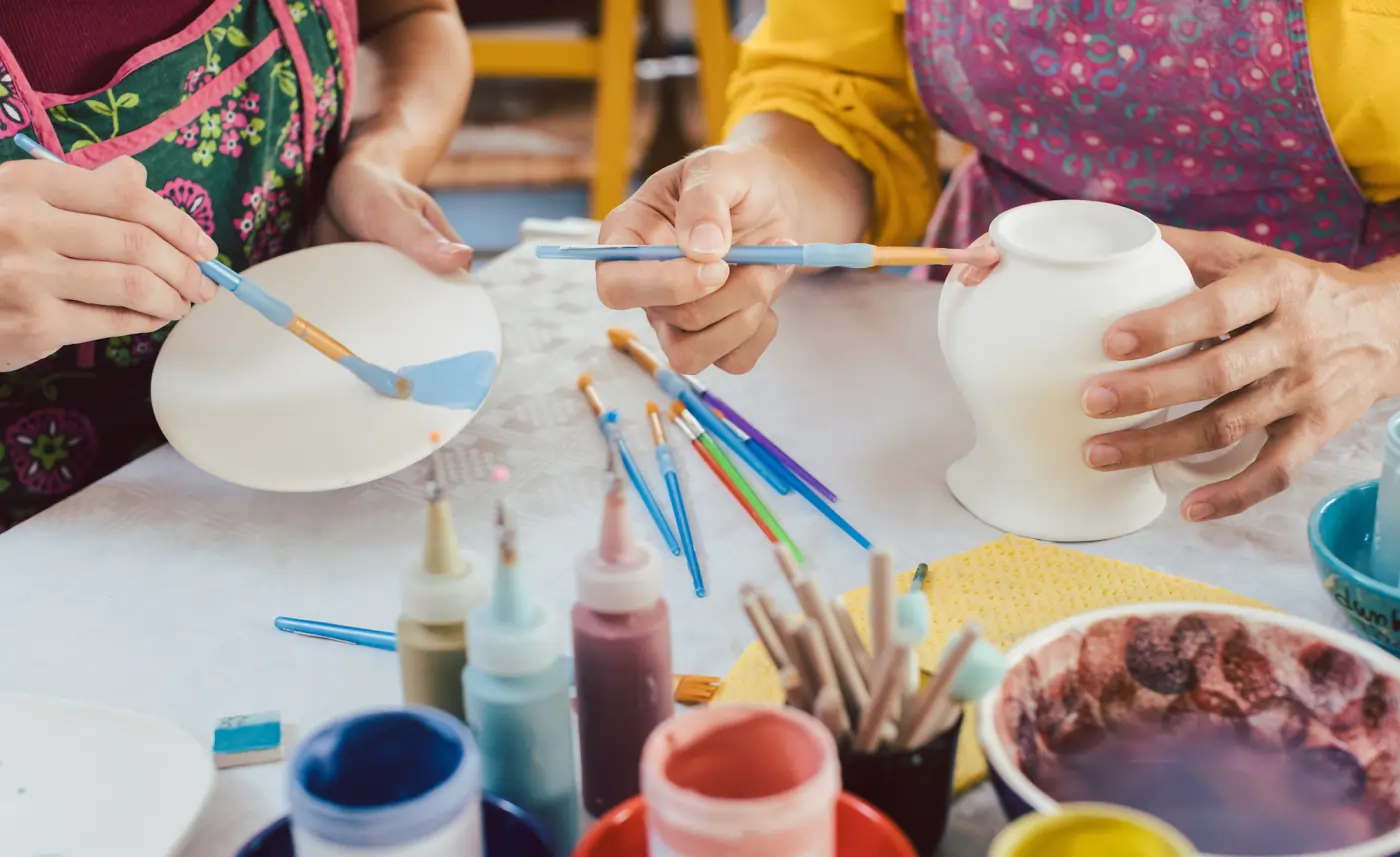 Two people painting pottery