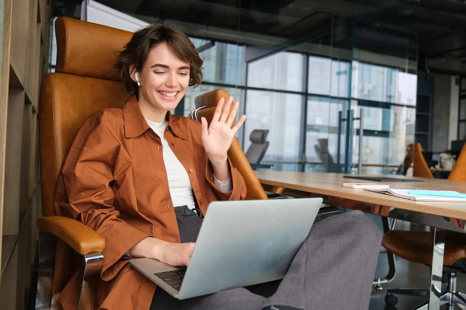 Lady waving to someone on laptop