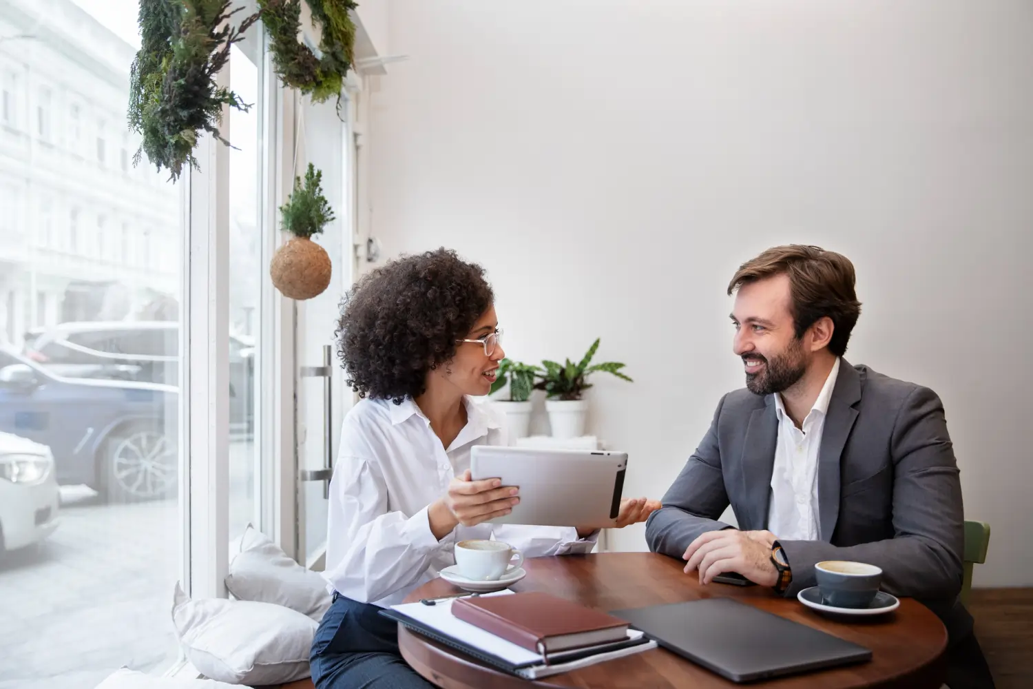 Colleagues talking at table by window