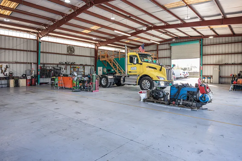Heavy equipment inspection of a yellow truck in a Florida repair bay before peak storm season ends.