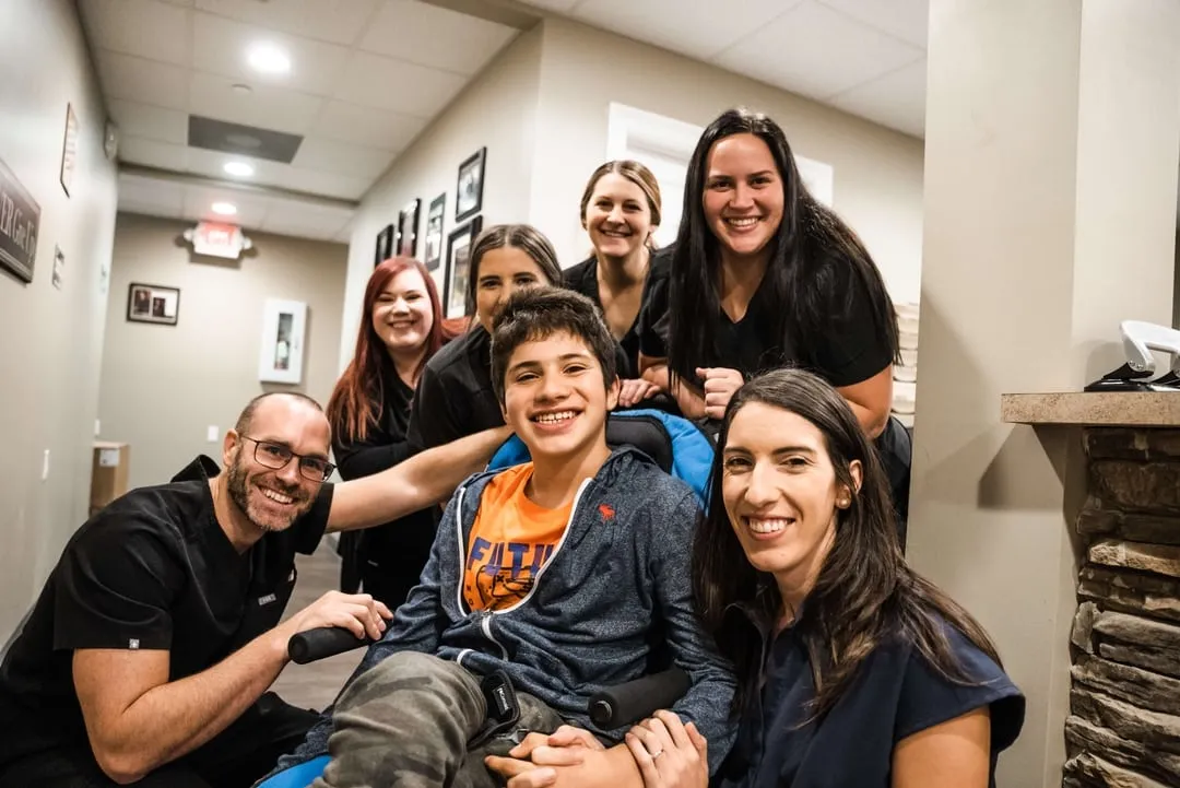 NeuroSolution Center of Lake Charles team members gathered around a pediatric patient smiling at the camera.