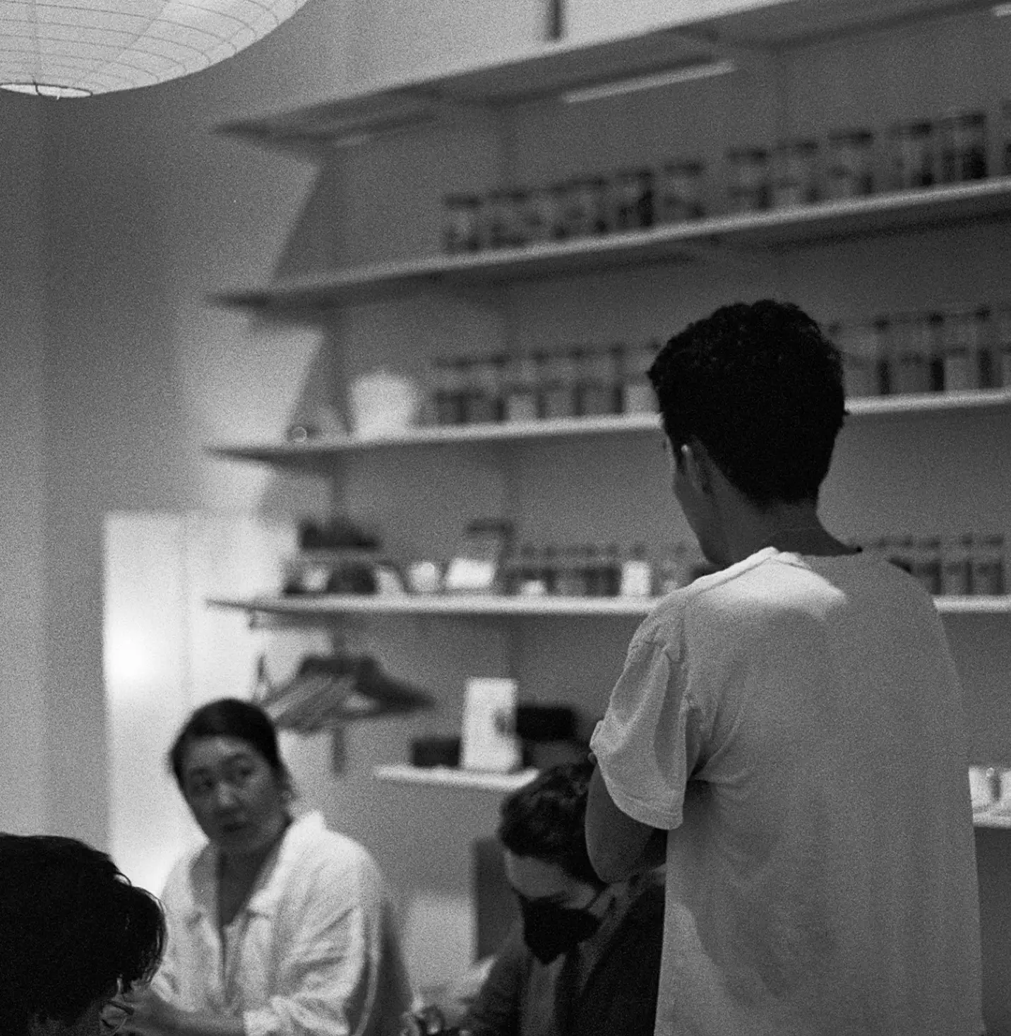A group discussion in a studio setting focused on teamwork and creativity, with art materials on shelves in the background.