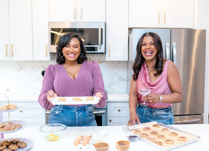 A mother and daughter duo joyfully baking in a bright kitchen, sharing love through their delicious creations.