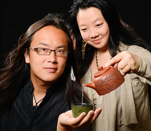A man and woman are serving tea, showcasing a unique tea experience with art and storytelling elements.