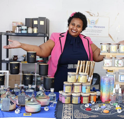 Gisela Andre, founder of Scent by Heaven, showcases her handcrafted candles in her vibrant candle store.