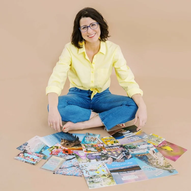 A woman in a yellow shirt sits cross-legged on the floor surrounded by colorful magazine pages.