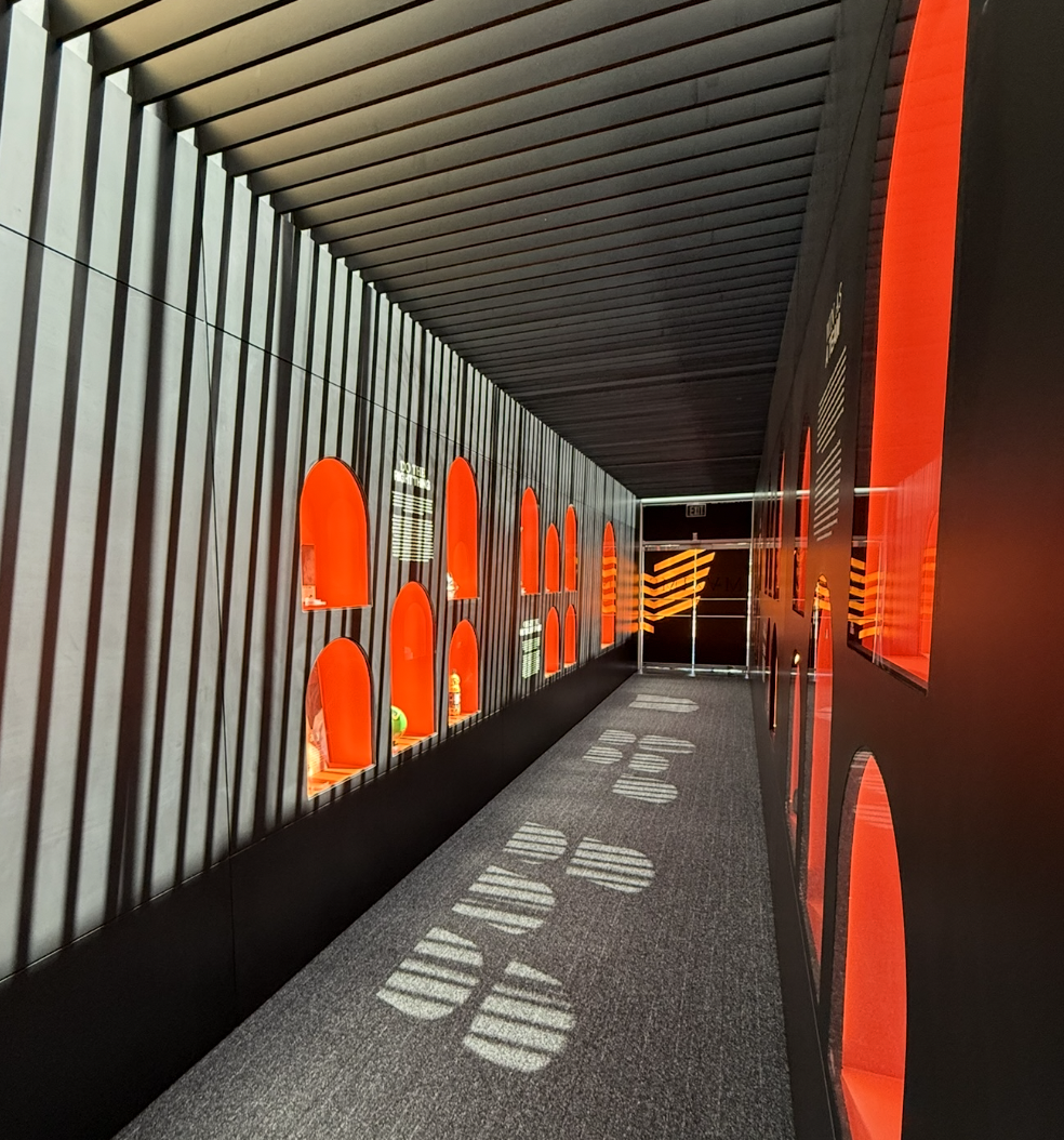Immersive hallway of the Nike Maxims Experience featuring illuminated red archway displays