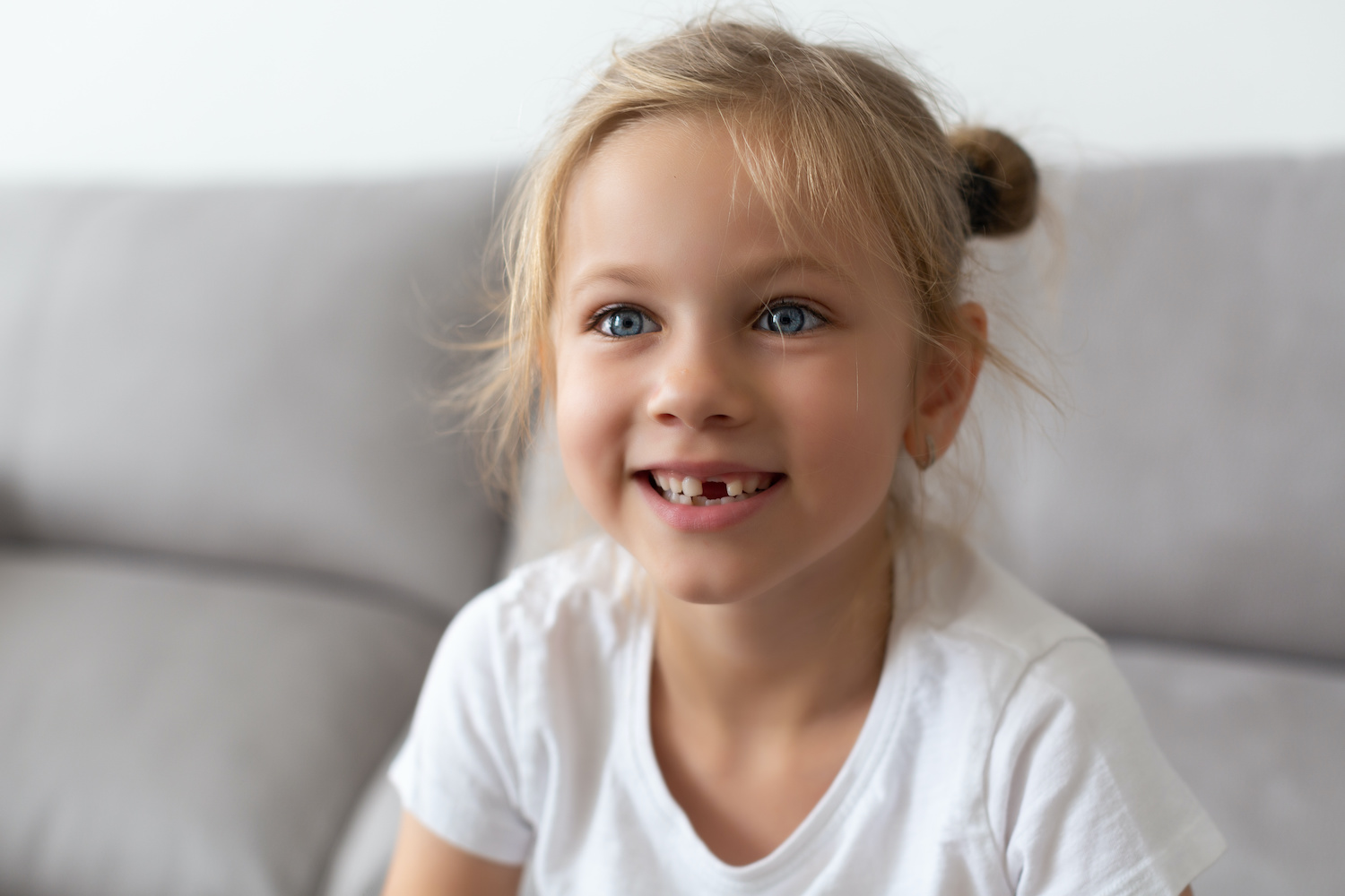 young girl missing a tooth and waiting for the tooth fairy