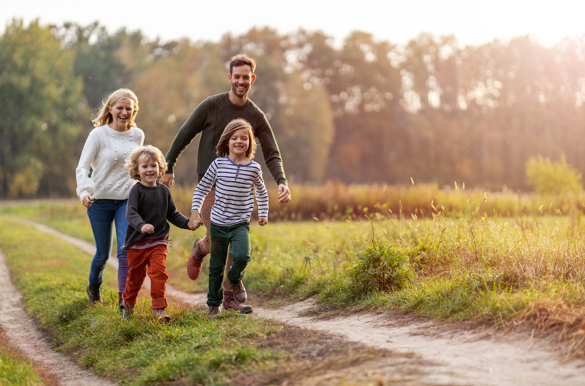 parents walking with their child outside on a sunny day