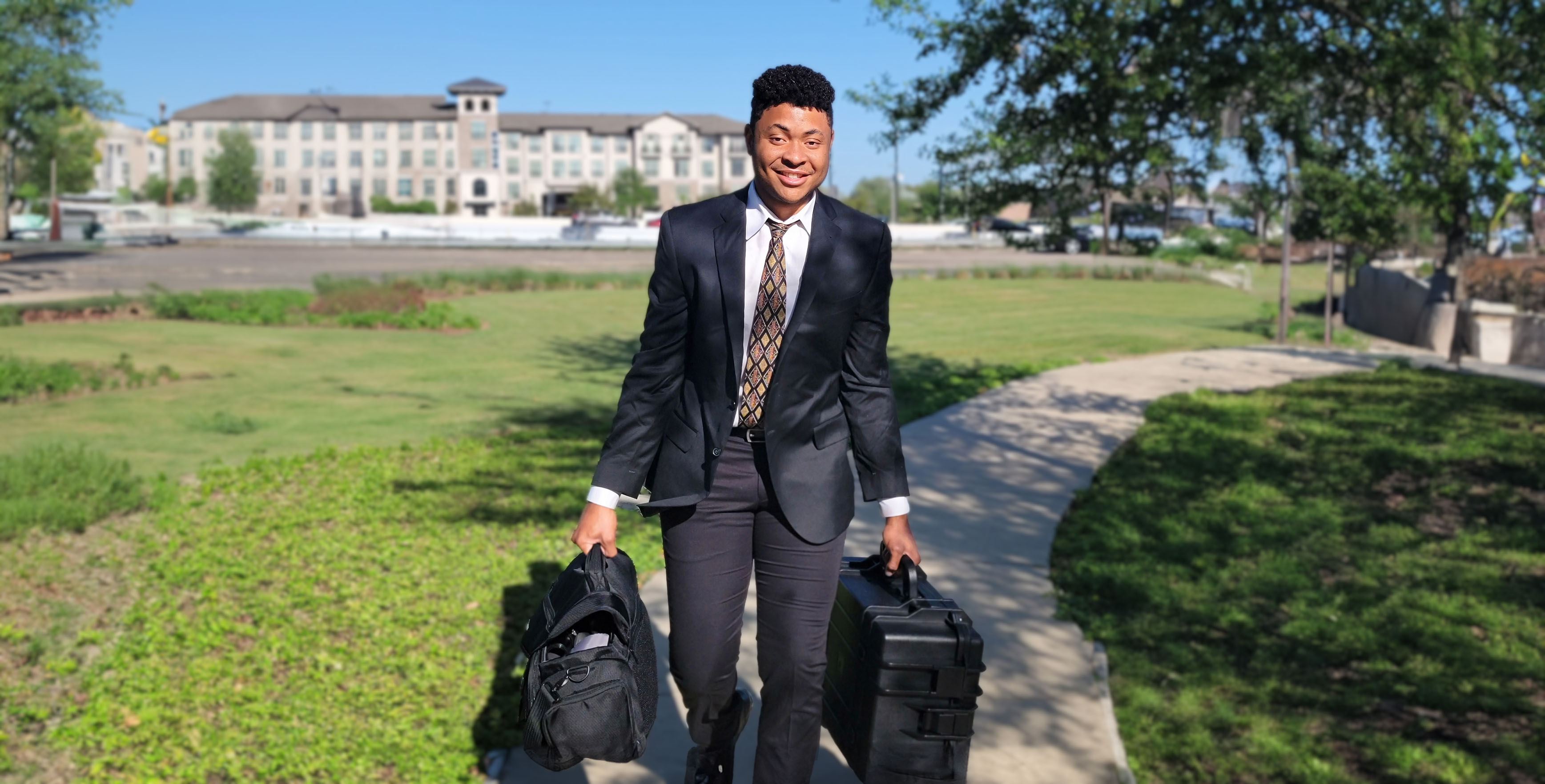 Cyrus walking towards the camera holding camera equipment.