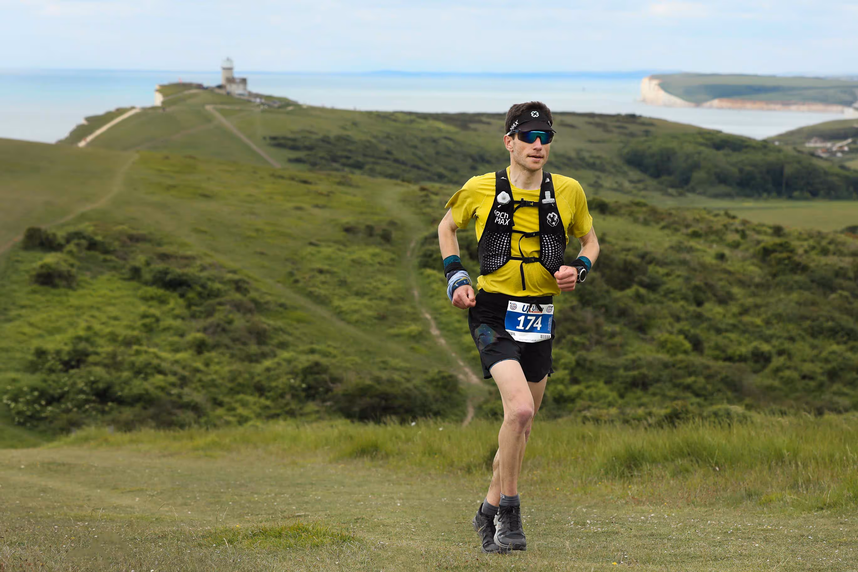 A runner in a yellow top concentrating on their run