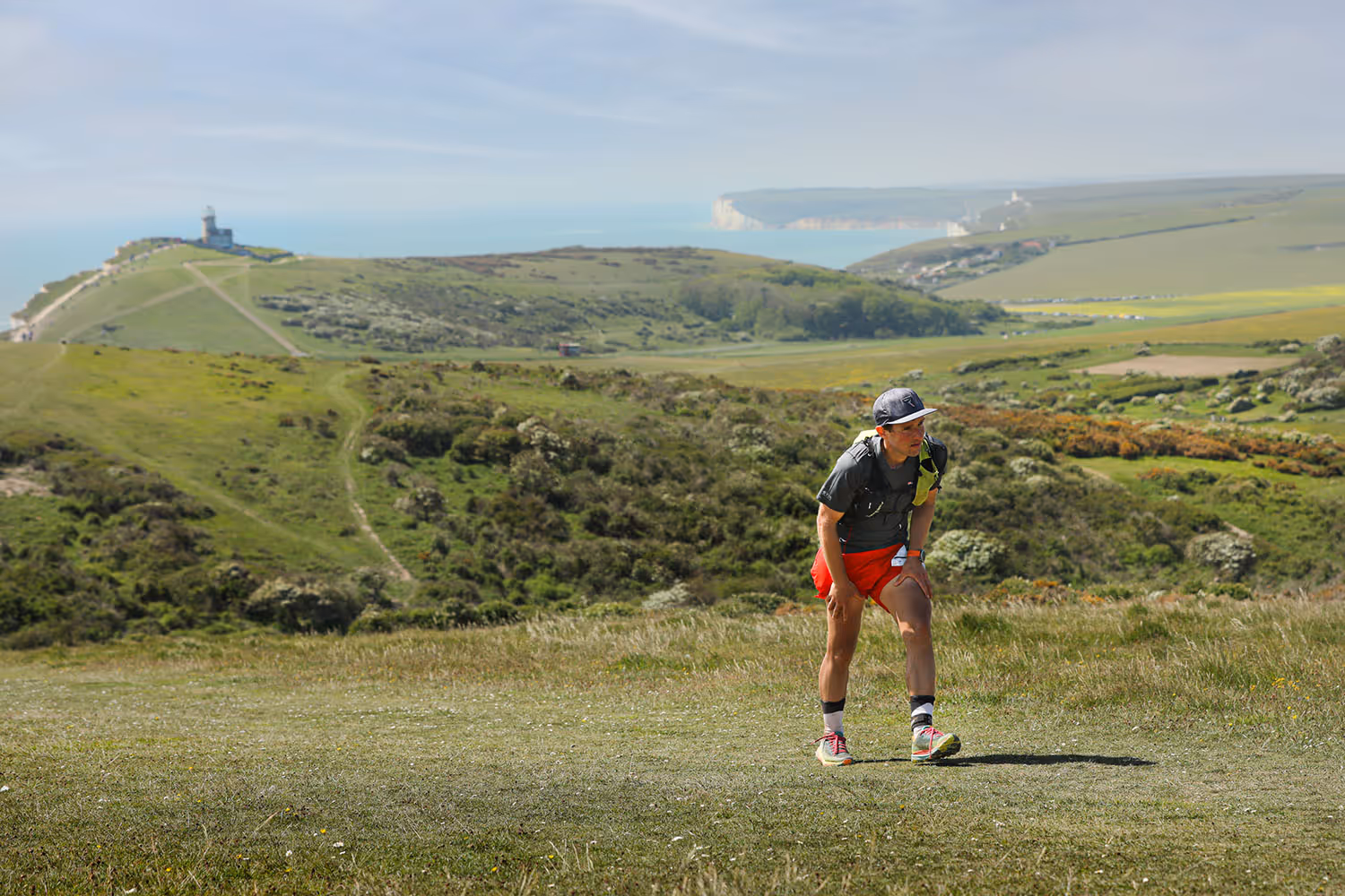 A runner bent over with their hands on their knees catching their breath