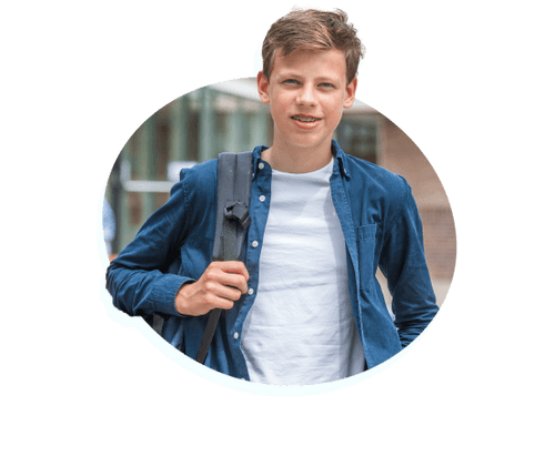 Trotse leerling poseert voor het schoolgebouw van het PCC Het Lyceum