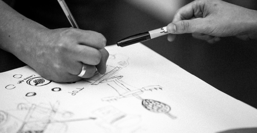 manos de personas trabajando en un proyecto en blanco y negro