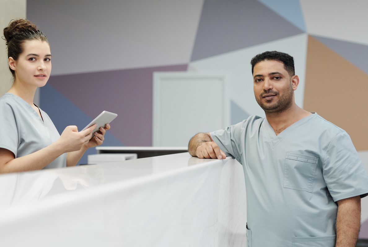 Medical staff members in scrub suits at a modern clinic's reception area.