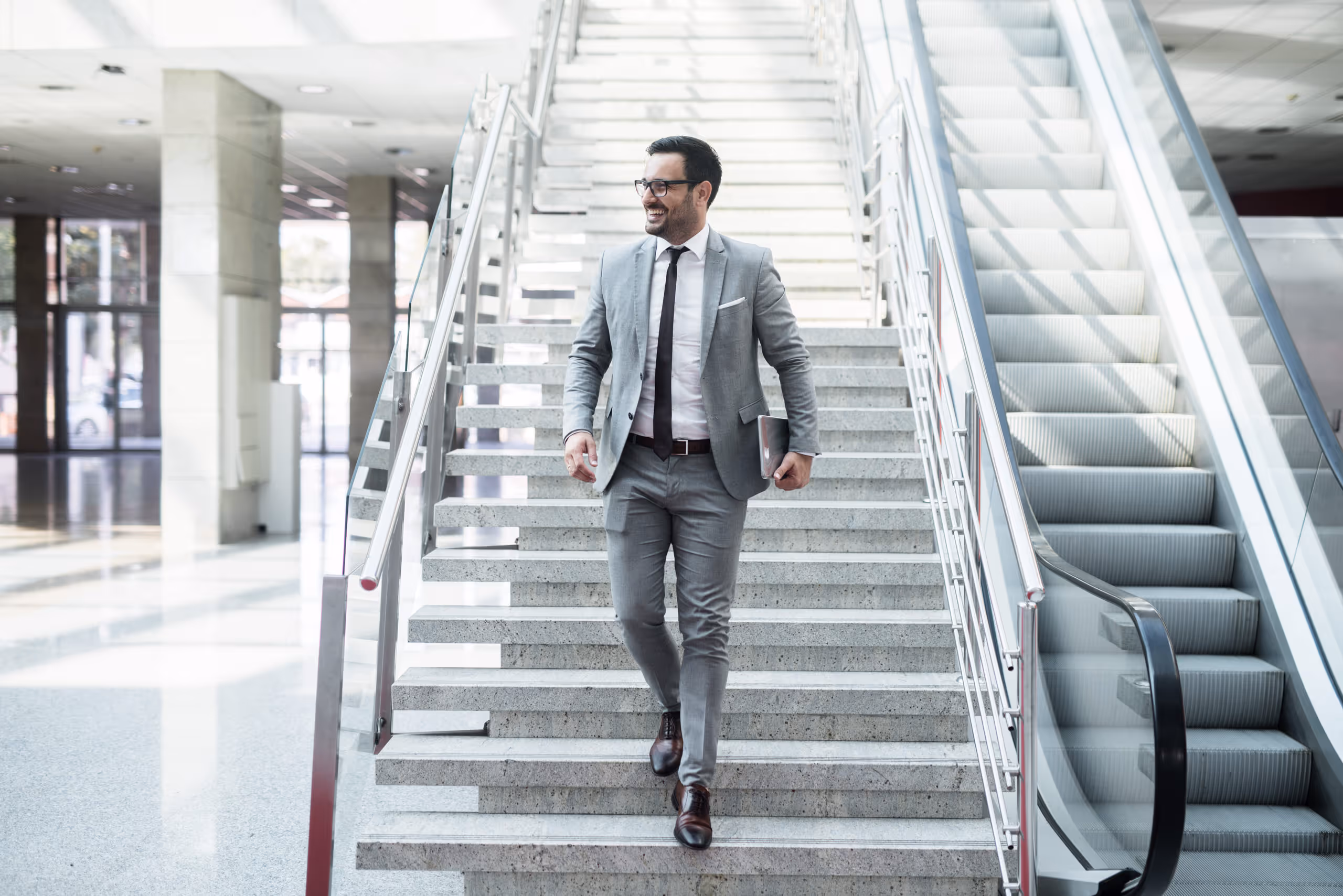 A man in a suit walking down a flight of stairs