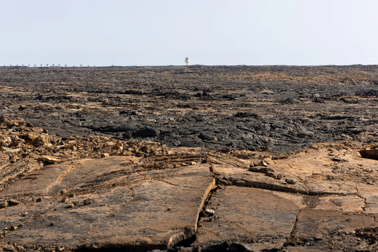 The orange rust oxidation on the pahoehoe surface in the 1801 flowfield. Kona airport in the distant background