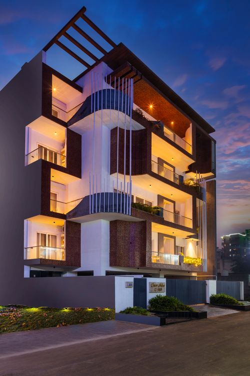 Casa Feliz — a modern three-story residence on Golf Course Road, Sushant Lok, featuring elegant warm lighting, spacious balconies, a sleek grey-and-white facade, and a secure gated entrance
