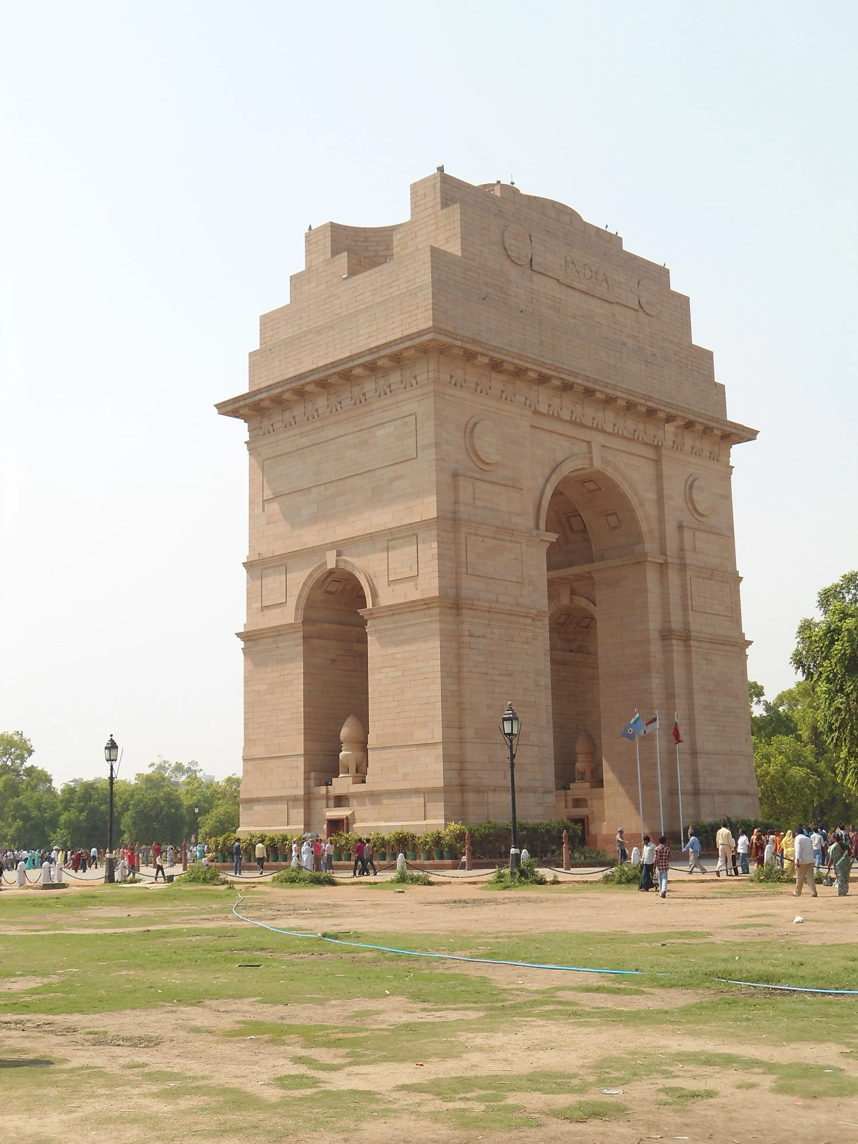 The India Gate war memorial with visitors walking around it on a sunny day.