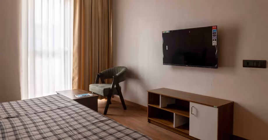 Bright bedroom in 2BHK in Casa Feliz with stylish furnishings, cozy bedding, and a flat-screen TV