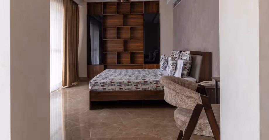 Bedroom at 2BHK in Casa Feliz with patterned bed, cozy interiors, and ample natural light – ideal for business travellers or families.