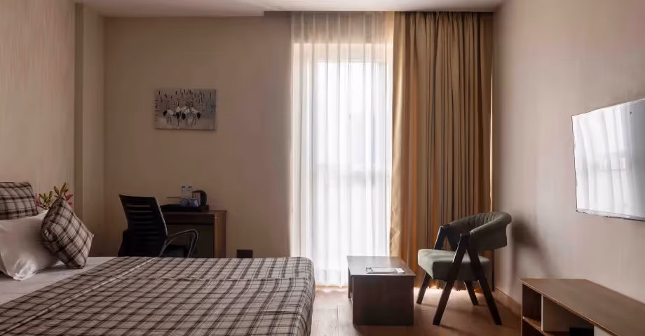 omfortable bedroom at 2BHK in Casa Feliz with modern interiors, bedside tables, and ample natural light – ideal for business travellers or families.