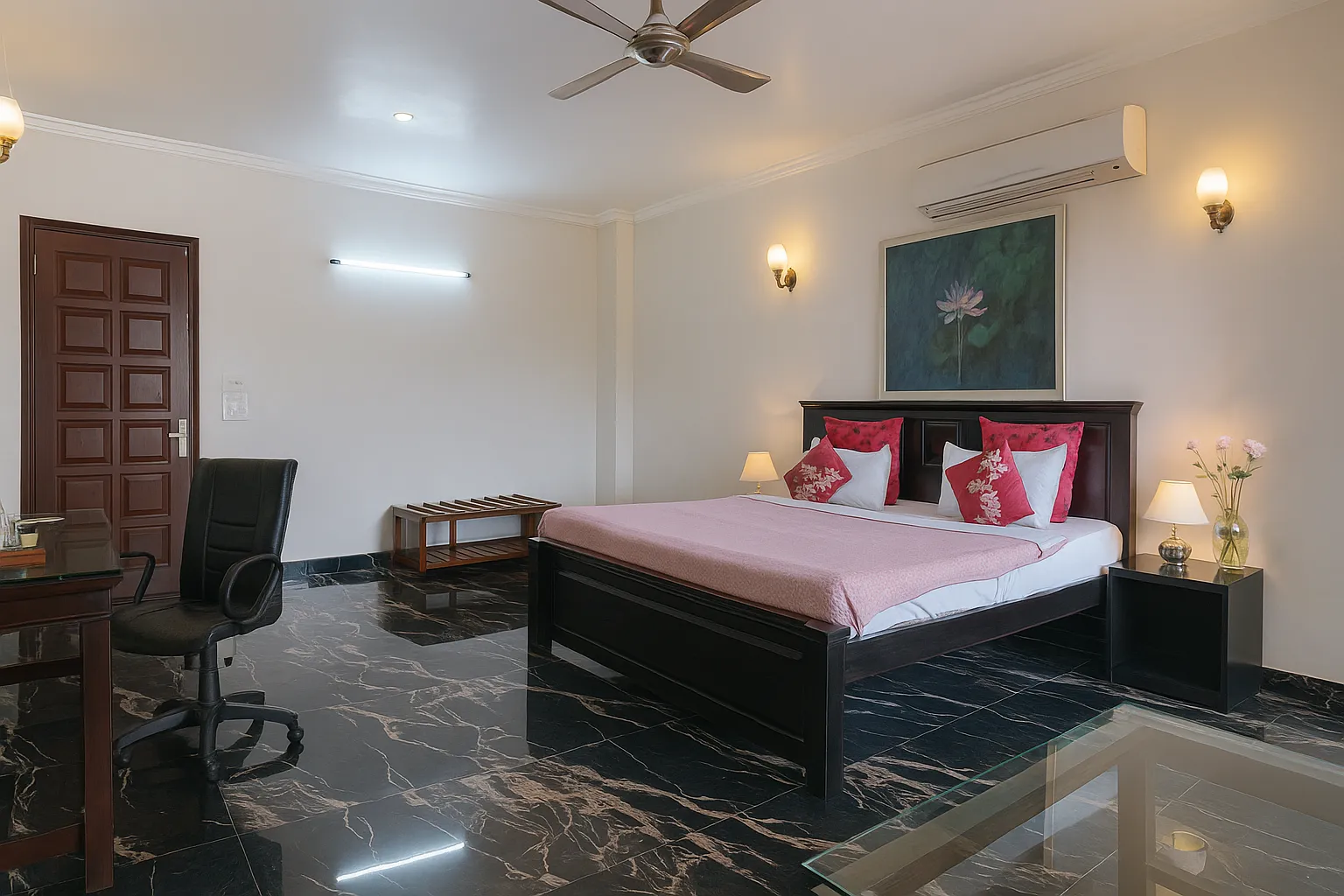 Well-furnished bedroom at Sterling Studio Apartment in Sushant Lok featuring a queen size bed, wardrobe, and comfortable seating area.