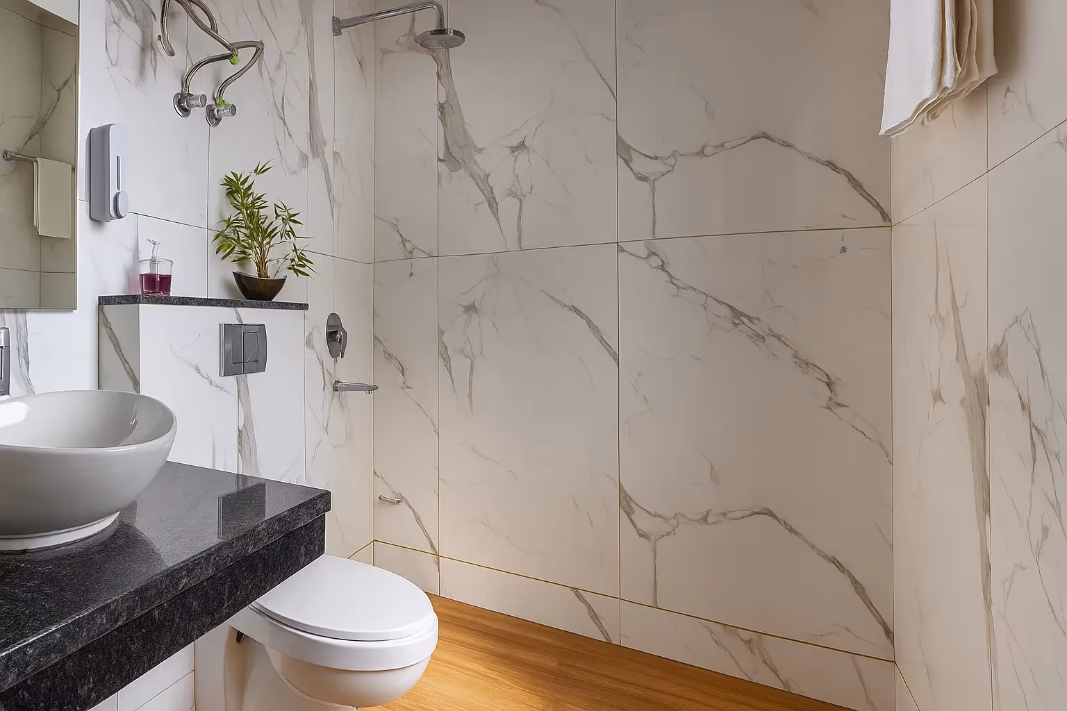 Elegant bathroom in Classic Studio MG Road by Perch featuring marble wall tiles, a modern vanity and glass shower.