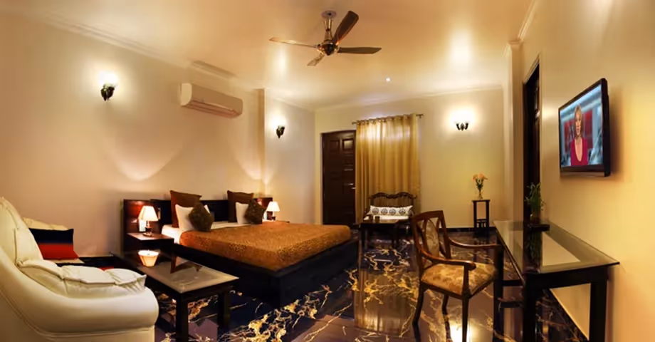 Dining area at Sterling Studio Apartment in Sushant Lok with a wooden dining table, chairs, and cozy lighting – ideal for business travellers or families.