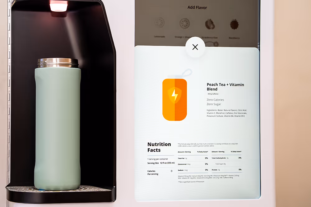 Smart water dispenser with a mint green insulated bottle and a screen showing nutritional information for Peach Tea + Vitamin Blend with zero calories and sugar.
